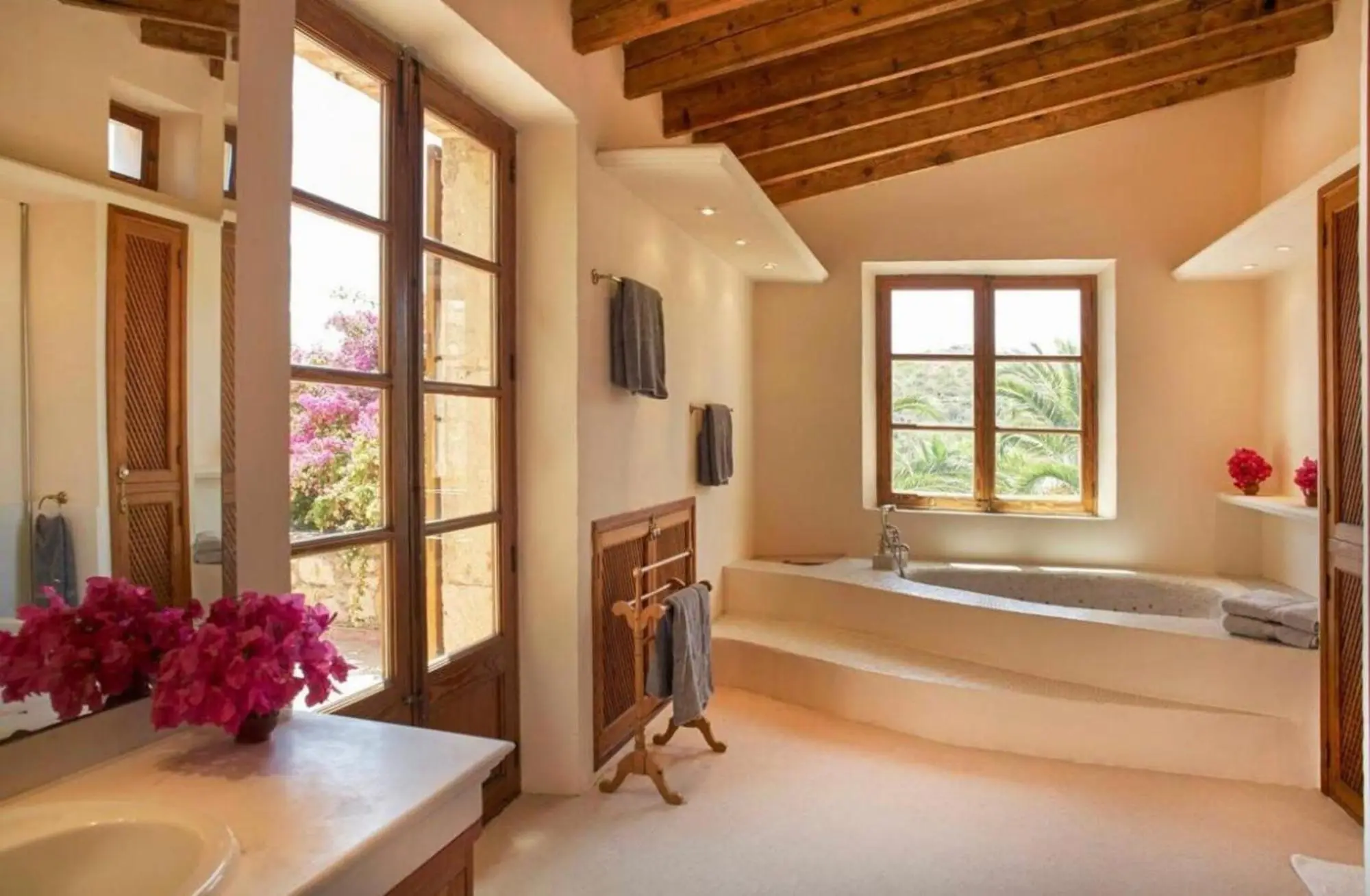 Bathroom with a sunken tub below the window and French doors to the garden