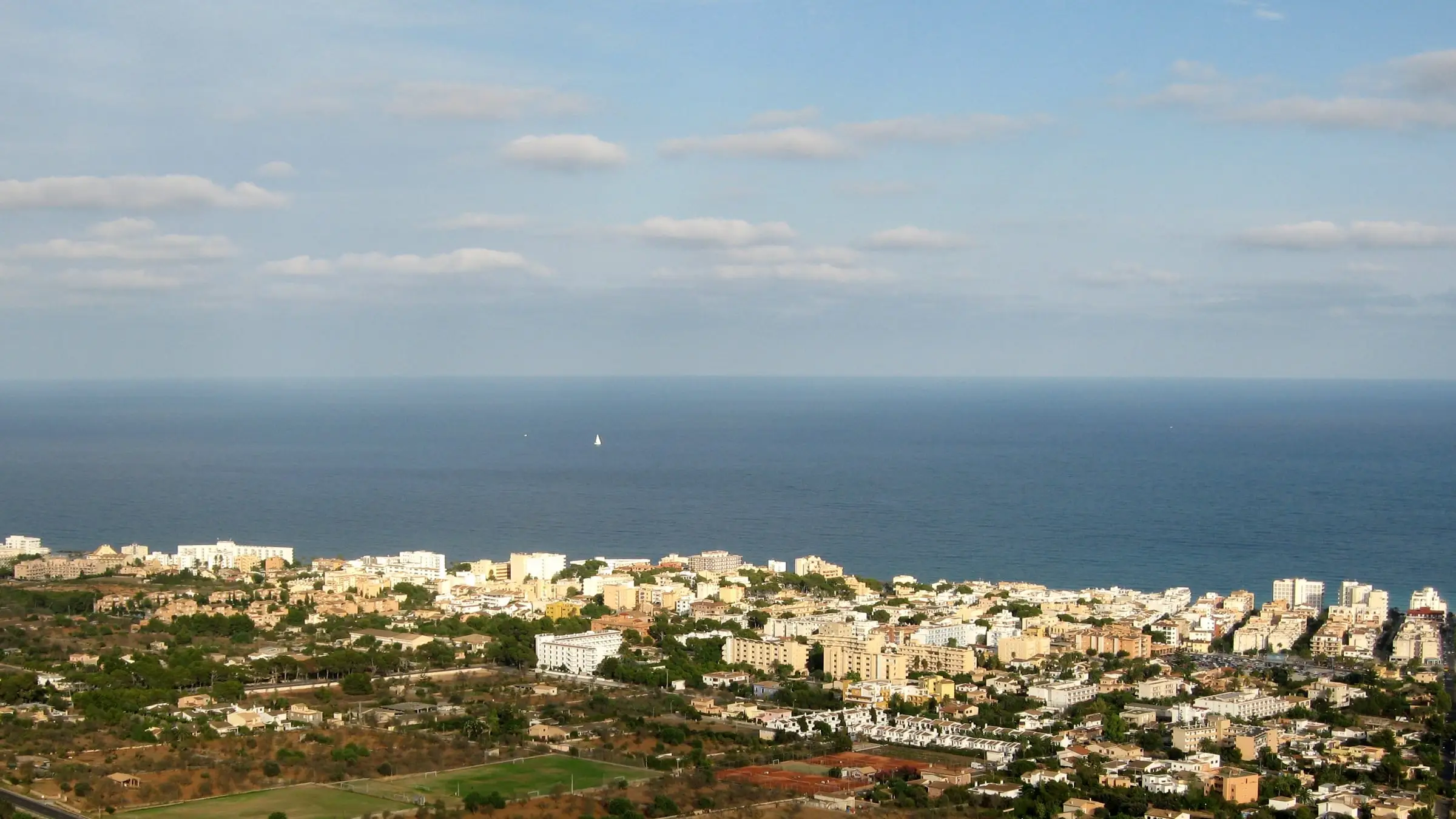 View over Cala Millor towards the sea, the fields behind the town in the foreground