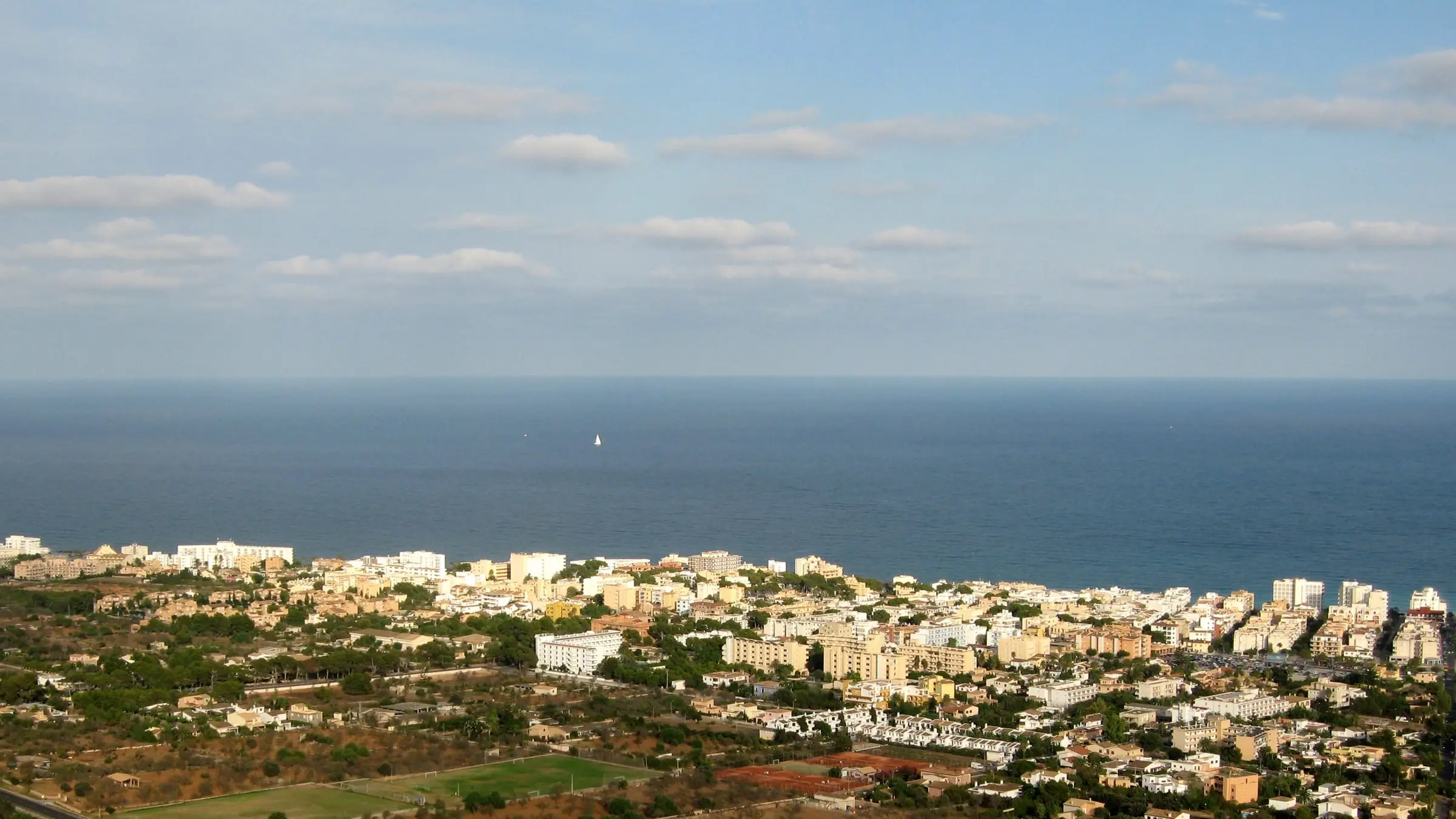 View over Cala Millor towards the sea, the fields behind the town in the foreground