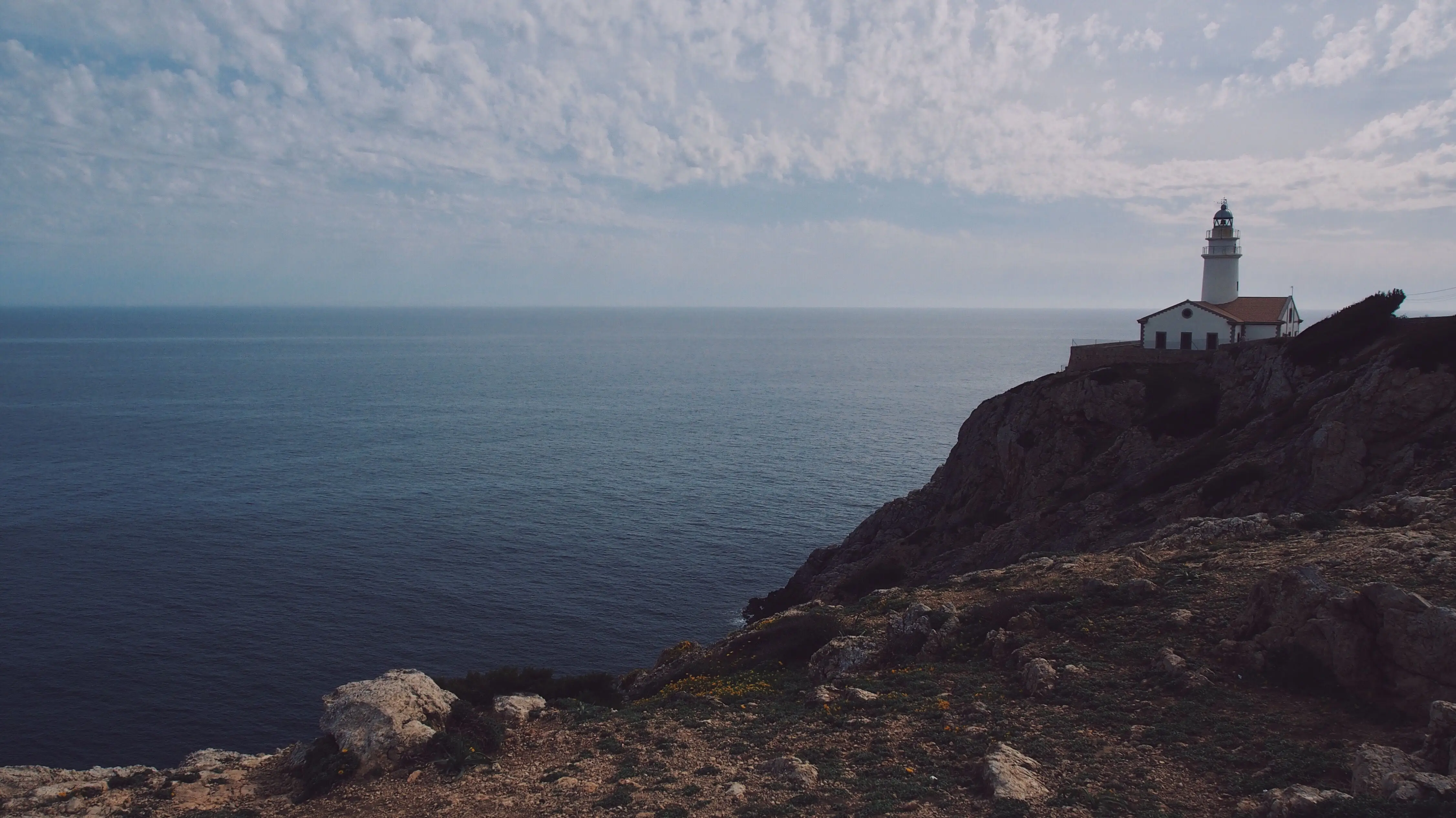 The Far de Capdepera lighthouse on the headland above Cala Ratjada, open sea beyond