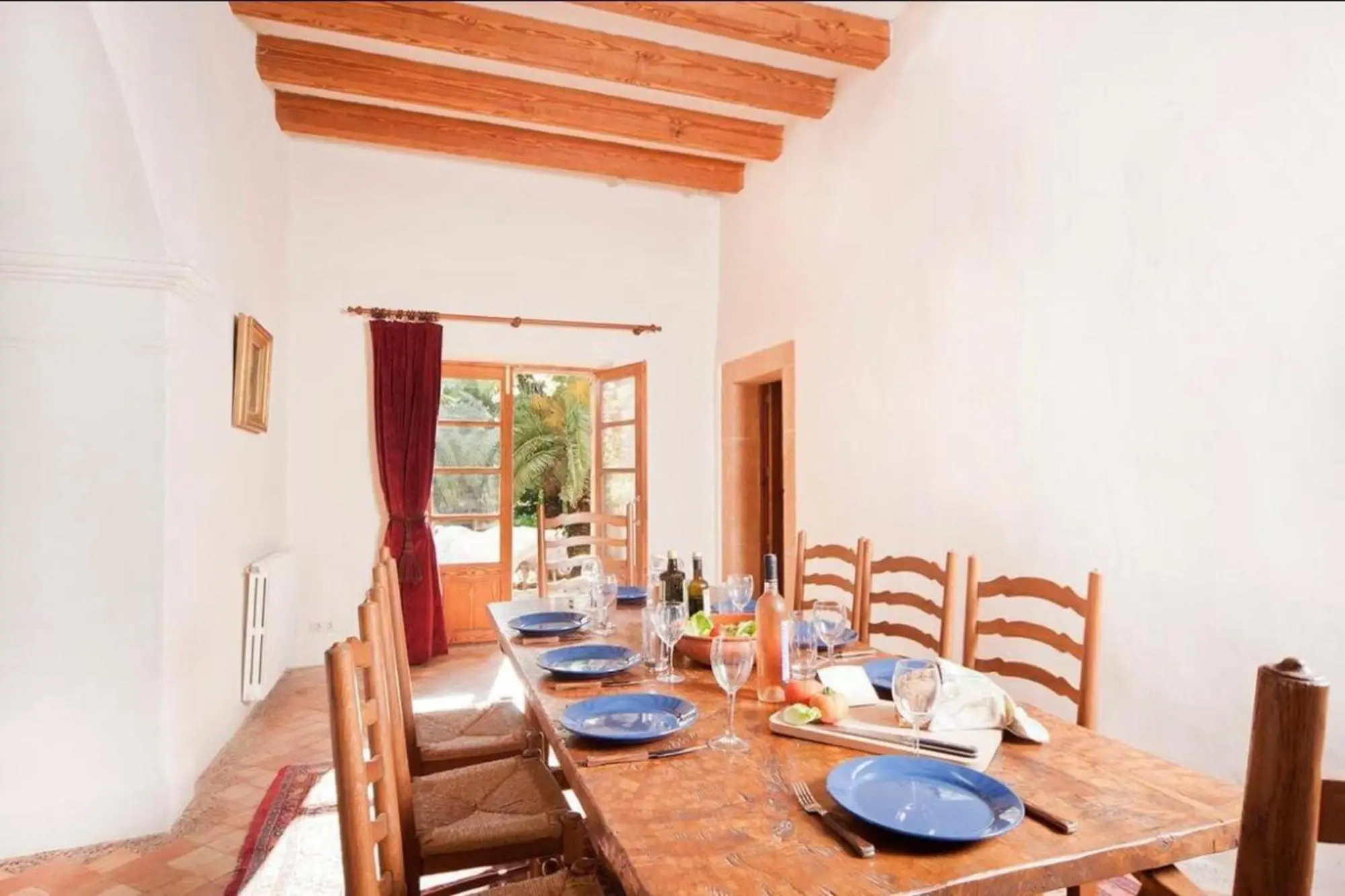 Laid wooden dining table in front of the French doors to the garden