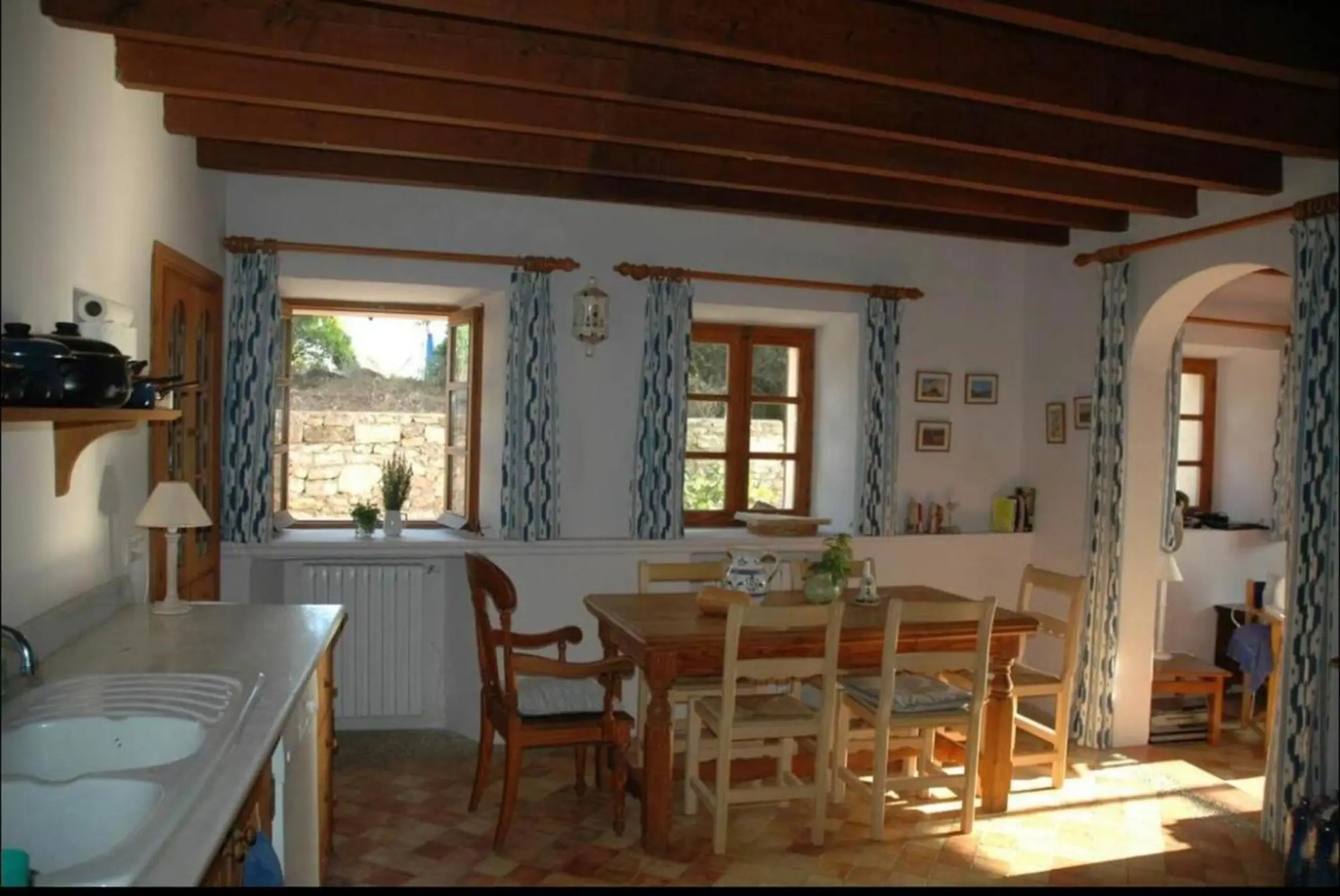 Kitchen with dining area, beamed ceiling and an arch to the adjoining room