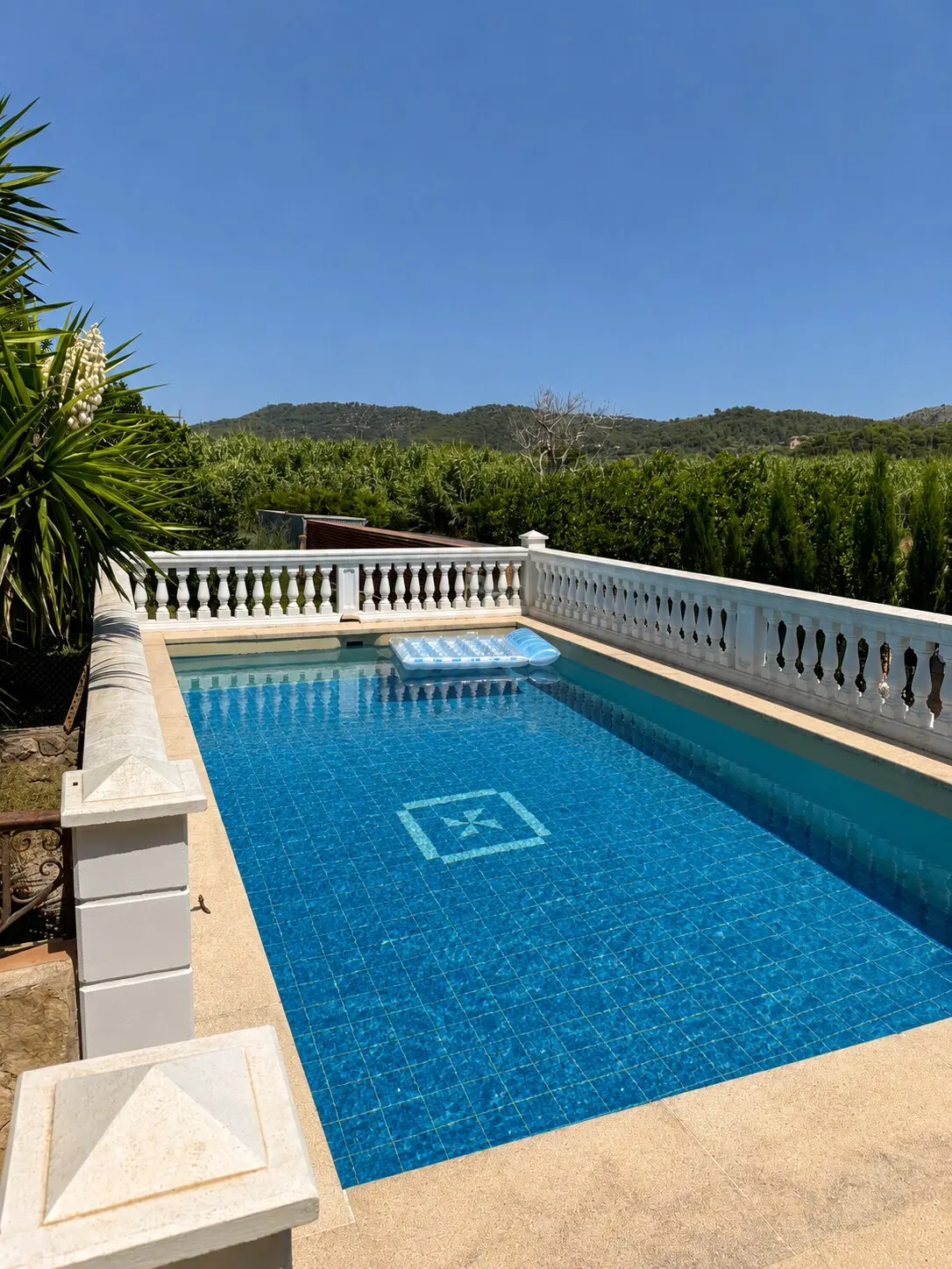 Pool with a rendered balustrade, fields and the eastern hills behind