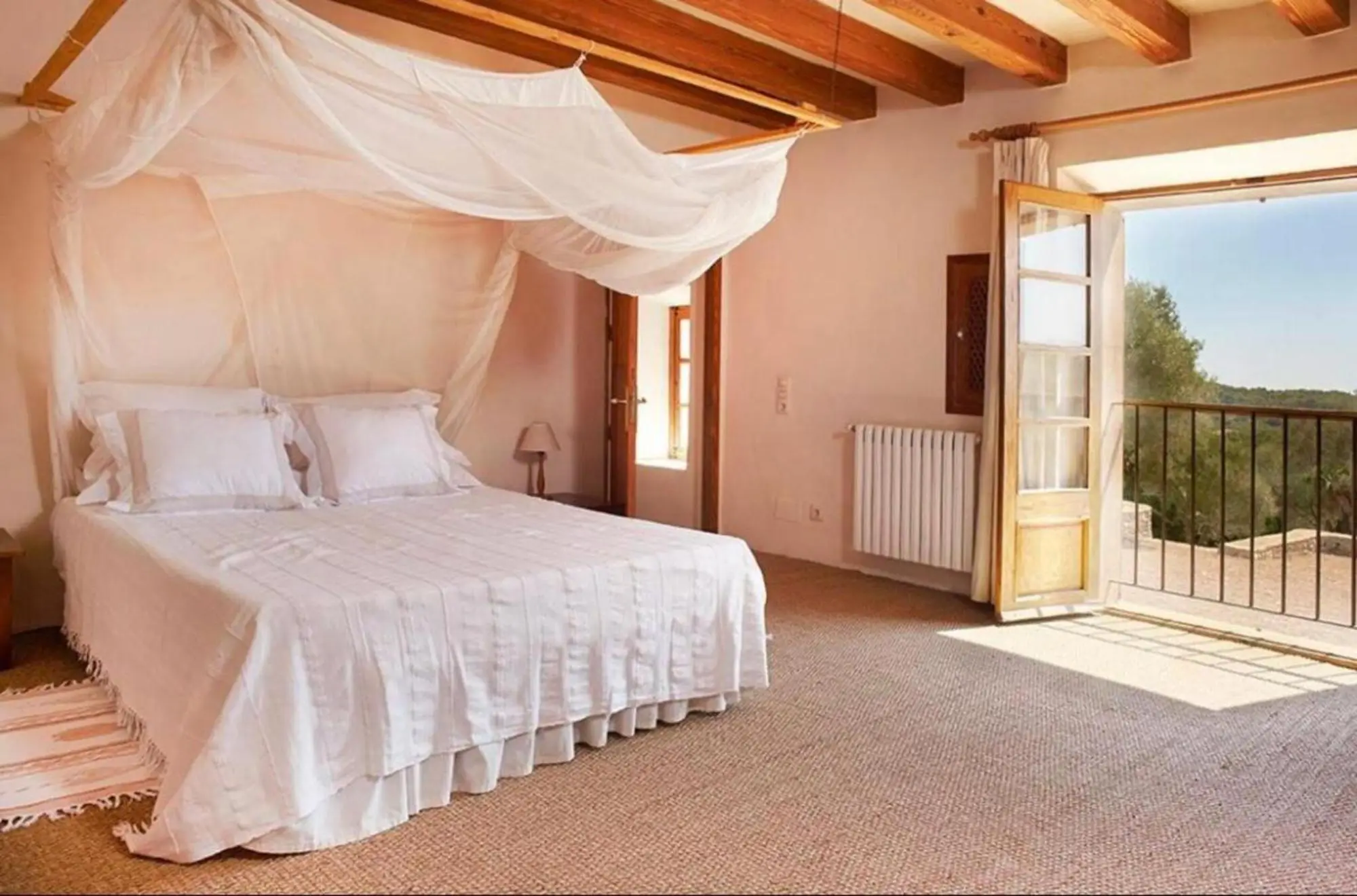 Bedroom with four-poster bed and a French door onto the balcony