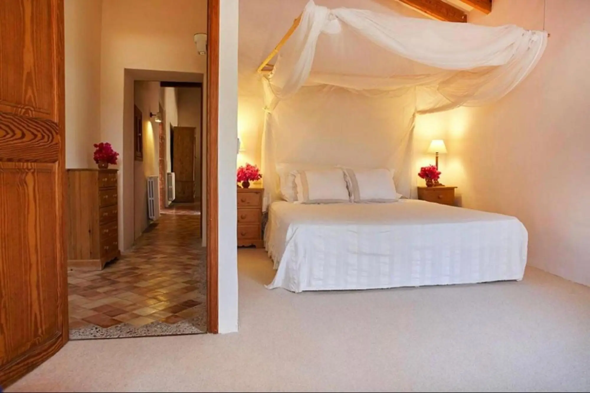 Bedroom with four-poster bed, looking through the door into the hall
