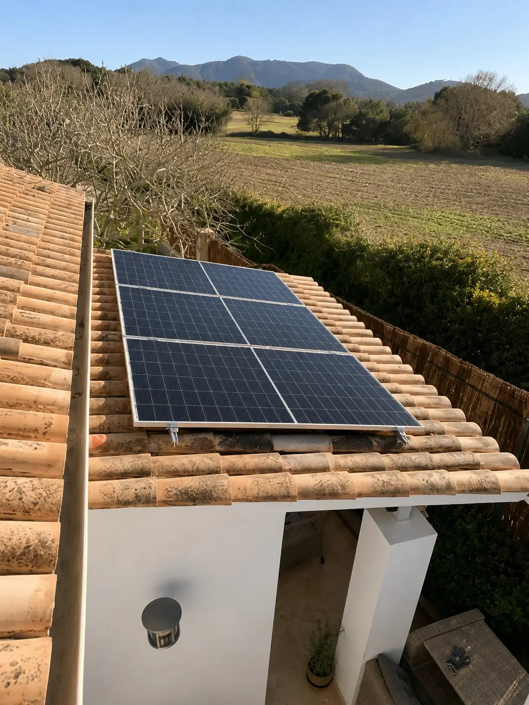 Solar panels on the tiled roof, fields and hills behind